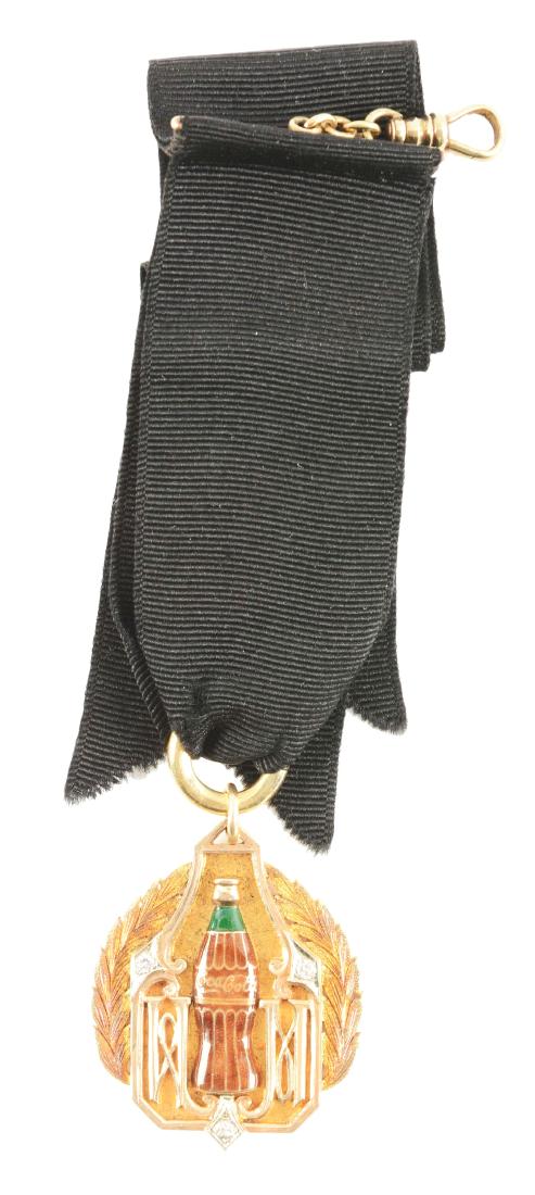 1930's 14k Coca-Cola 100,000 Gallon Club Medallion.: This medallion is 14k gold and features a cloisonne bottle surrounded by three diamonds with wreath detailing. These medallions rarely appear, and are very desirable. From the Ray Bentley Collection.