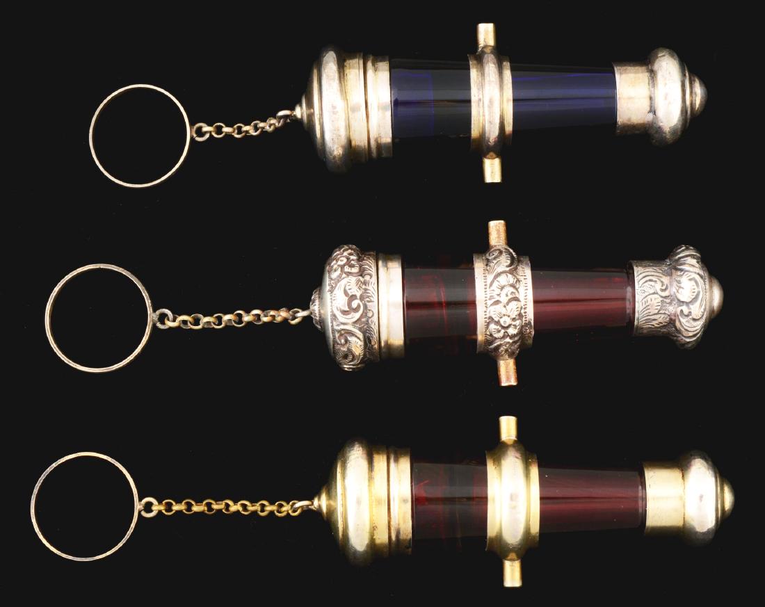 Lot Of 3: Cannon Shaped Vinaigrettes & Perfumes.: Lot includes: two perfume bottles in cranberry glass and one cobalt blue glass. All are are similarly shaped and have finger rings. Circa mid-1800's. Condition: (Excellent). Item Dimensions: Each: 3 -