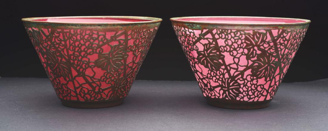 Pair Of Tiffany Studios Grapevine Candle Lamp Shades.: Pair of Tiffany candle lamp shades have acid etched bronze overlays in the grapevine pattern. The bronze is finished in a reddish brown patina. Each shade is complete with a red glass liner. Both are 