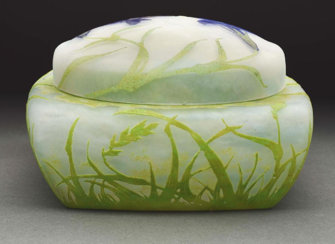 Daum Cameo Box.: Daum dresser box has light green cameo leaves and stems surrounding all four sides and climbing onto the round lid. The lid is further decorated with three dark blue padded and wheel carved flowers. A
