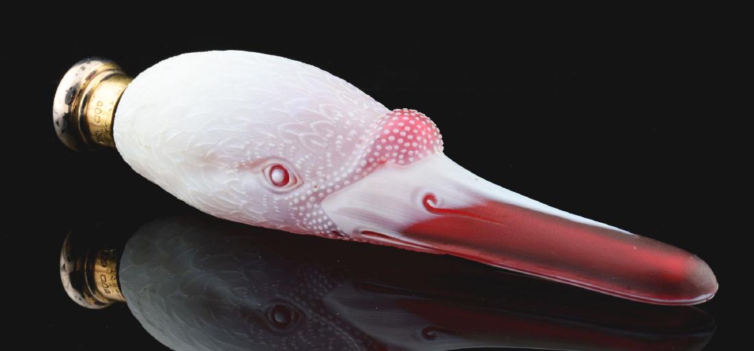 Rare Thomas Webb Cameo Glass Perfume Bottle.: Perfume bottle is a carved swan with ruby glass bill and eyes, and finely carved feathers. Circa 1884. Figure is etched "Rd 11109" and has a hallmarked sterling silver lid. 5-1/2" long. There is a tin