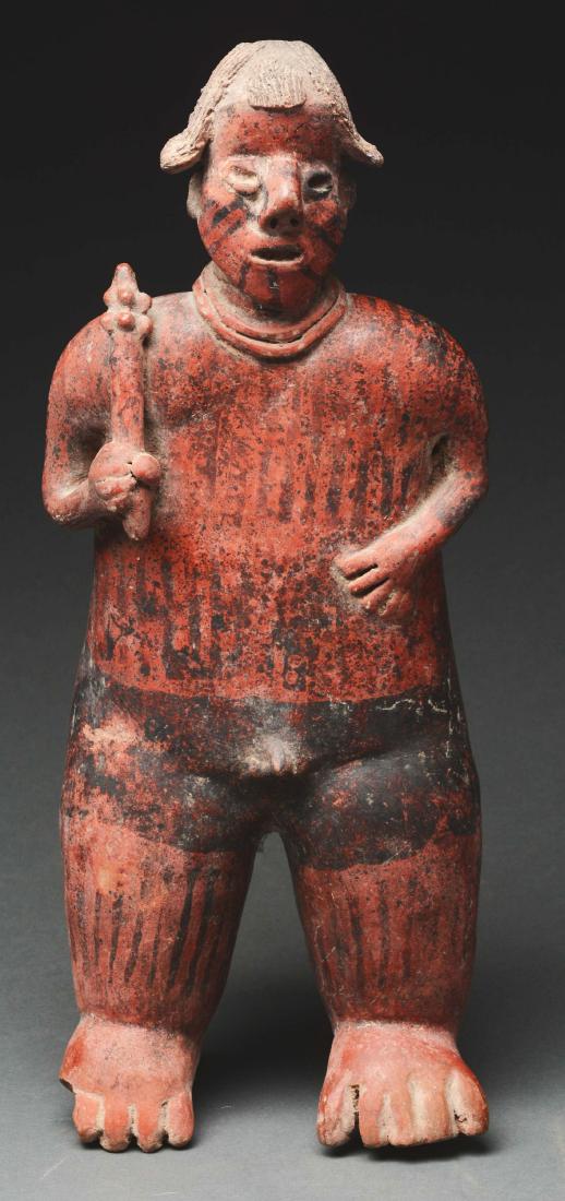 Terra Cotta Warrior ,West Coast Culture, Nayarit,: A.D. 300 - 950. Nayarit, Mexico. The polished figure of a warrior holding a studded club in right raised hand, his left arm in a defensive position. The head molded with deep set eyes and open mouth, 