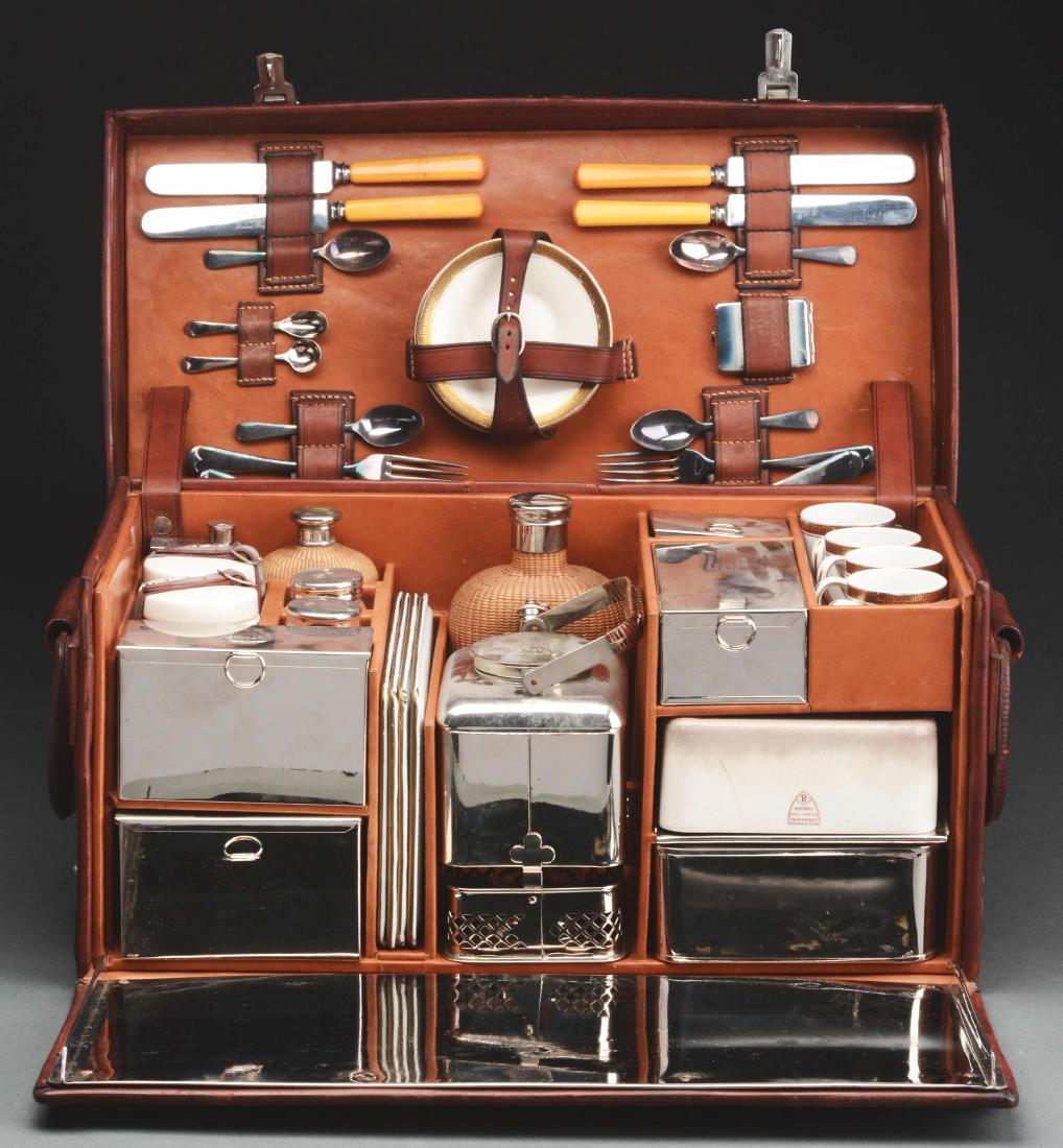 Cased Picnic Set.: Cased picnic set has metal tea pot with warmer, plated metal pocket flask, plated metal storage box, plated metal sugar box, glass salt and pepper shakers with woven basket coverings, a glass flask wi