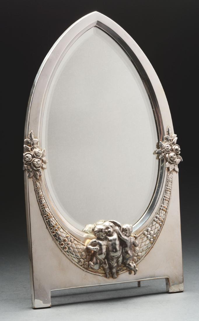 Sterling Silver Plated Table Mirror.: A WMF Silver Plated Table Mirror, the pointed oval beveled plate with a conforming frame chased with a laurel wreath and applied with a group of cherubs, the wood back with an adjustable strut. Height