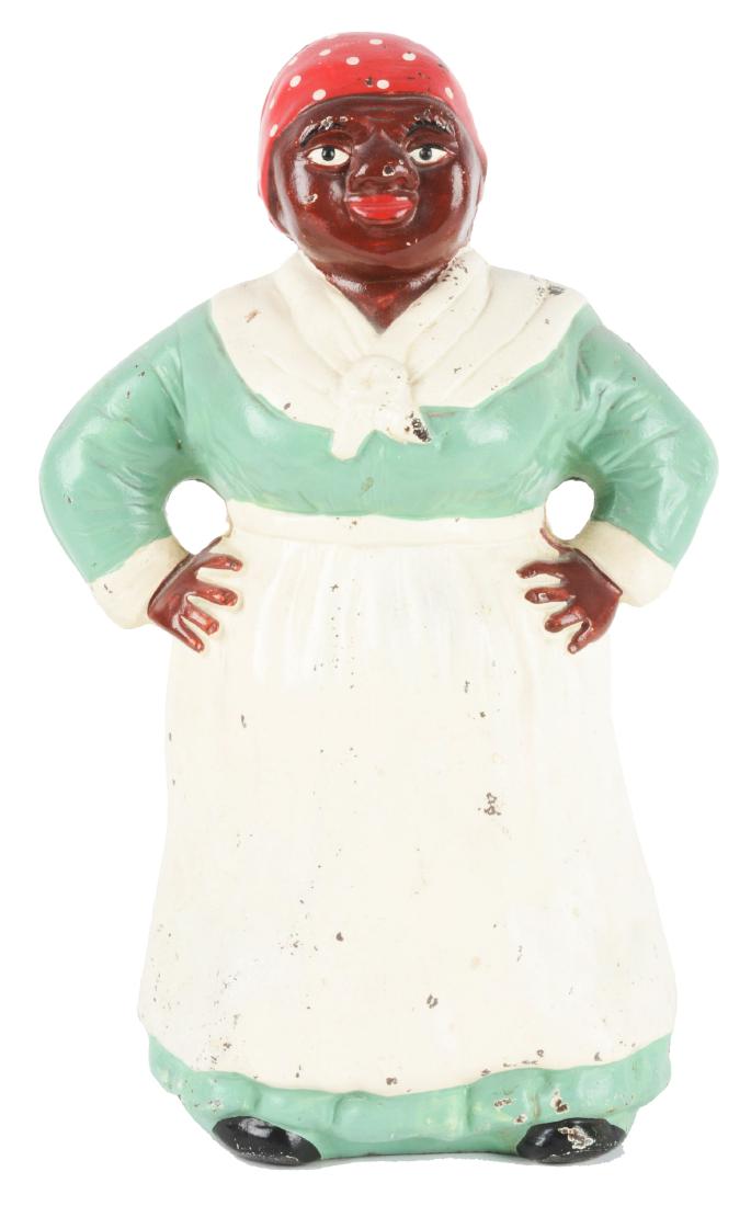 Cast Iron Southern Mammy w/ Hands on Hips Doorstop.: Depicts full-figure mammy with hands on hips, wearing traditional apron and scarf. Rarer green dress variation. Made by Hubley. Condition: (Excellent).Dimensions: 11 -1/4" x 7 -1/2".