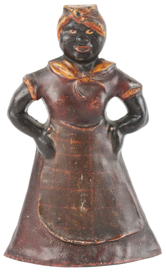 Cast Iron Mammy with Hand on Hips Doorstop.: Typical pose of Mammy wearing bandana and apron, with hands on hips. Rarest of the Mammy doorstops produced. Superb piece of Black Americana. Condition: (Very Good).Dimensions: 10 - 1/4" x 6 - 1/2".