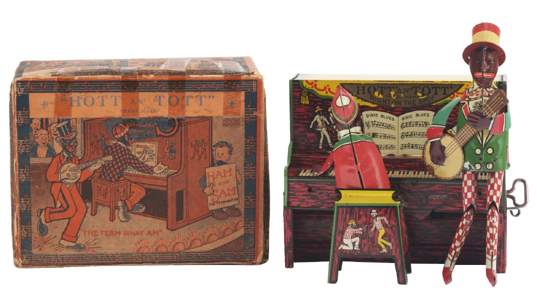 Unique Art Hott An' Tott Litho Wind Up Band Toy With: Includes very colorful and difficult to find original box showing minstrel team playing piano and banjo. Box is marked "The Team What Am" and "Ham and Sam". Piano has slight edge wear and is all origi