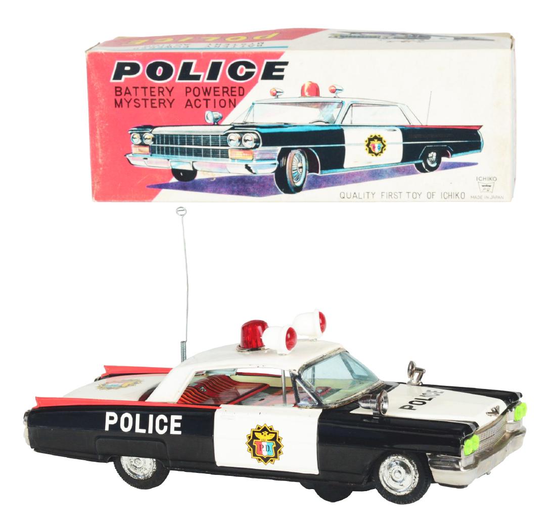 Tin Litho Battery Operated Cadillac Police Car.: Japan, Ichiko. Works with mystery action, sound, light on top, and moving sirens, marked "Police" on rear fenders and hood, minor crazing on bottom, excellent, 11". Includes original box with inserts,