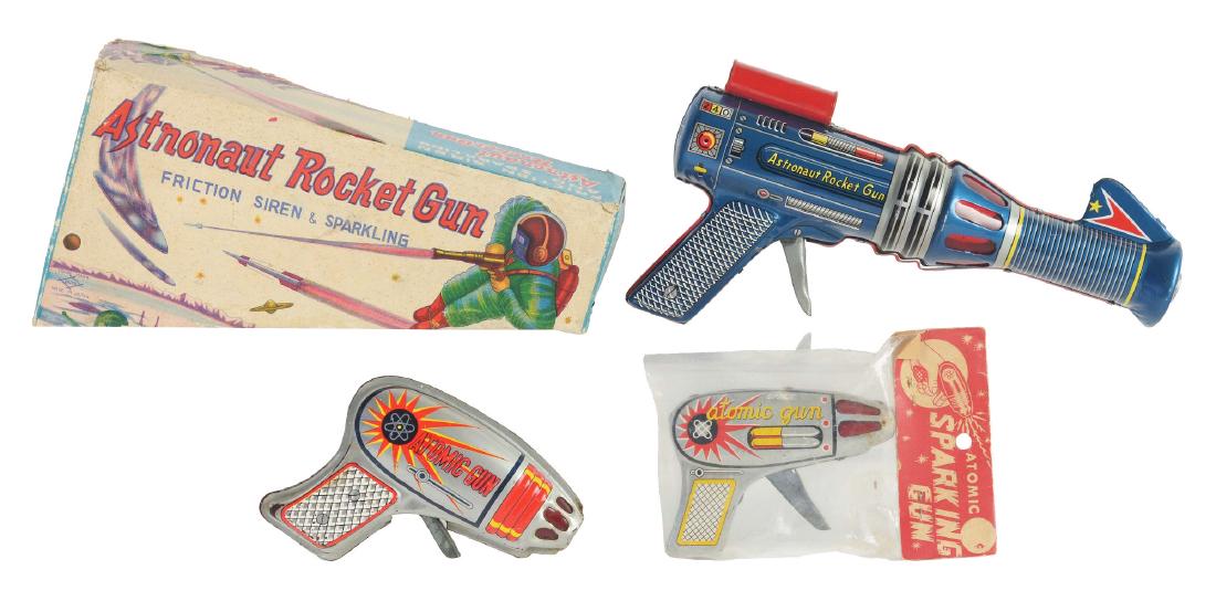 Lot of 3: Tin Litho Space Guns.: The first is a tin lithographed Astronaut Rocket Gun, Japan, Daiya. Works but no spark, excellent to near mint, 9-1/2". Includes original box, excellent. The second is a tin lithographed Atomic Sparki