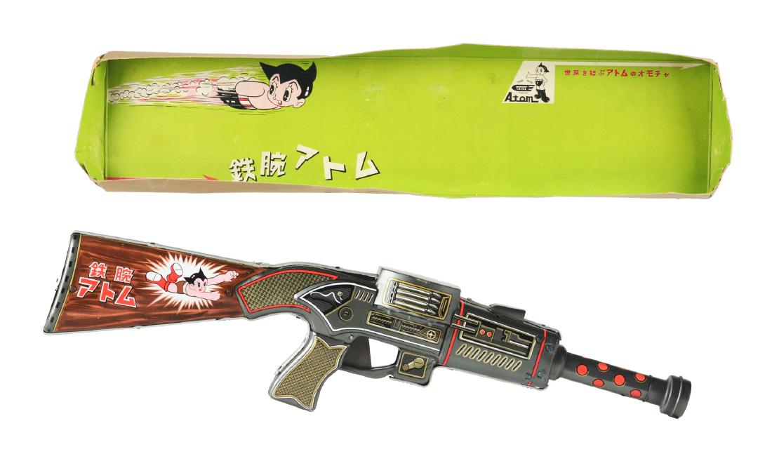 Tin Litho Battery Operated Astro Boy Smoke Rifle.: Japan, Tada. Rare Astro Boy Rifle with great action. The entire gun shakes back and forth while smoke is emitted from the vent on top of gun, works, near mint, 22". Box bottom has graphics possibly mi