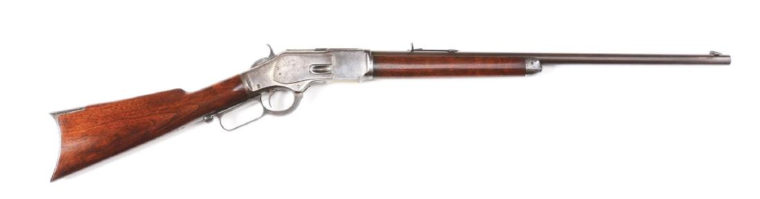 (A) Winchester 1873 Lever Action Rifle (1888).: This special order model 1873 Winchester features a full round barrel, special order button magazine, special order case colored receiver with case colored lever and hammer, rifle butt, walnut stocks,