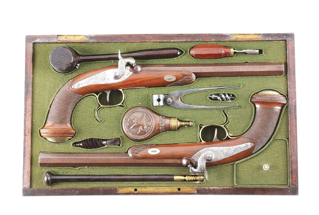 (A) GOOD CASE PAIR OF BELGIAN PERCUSSION DUELING: 9-3/4" octagonal barrels with silver foresights and pronounced damascus pattern. Bolted back action locks with sparse floral engraving. Hammers with sparse floral engraving en suite. Spurred white bra