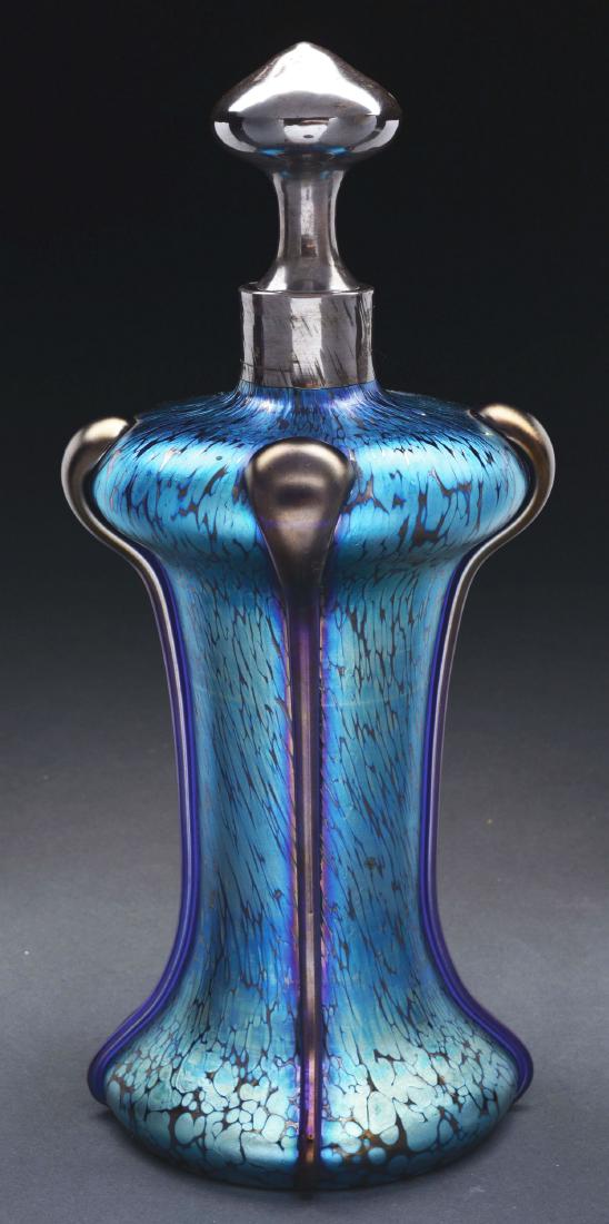 Loetz Papillon Decanter.: Loetz decanter in the papillon genre has bright blue iridescence with subtle flashes of gold at the foot. The decanter is further decorated with four applied glass tendrils descending from the shoulde