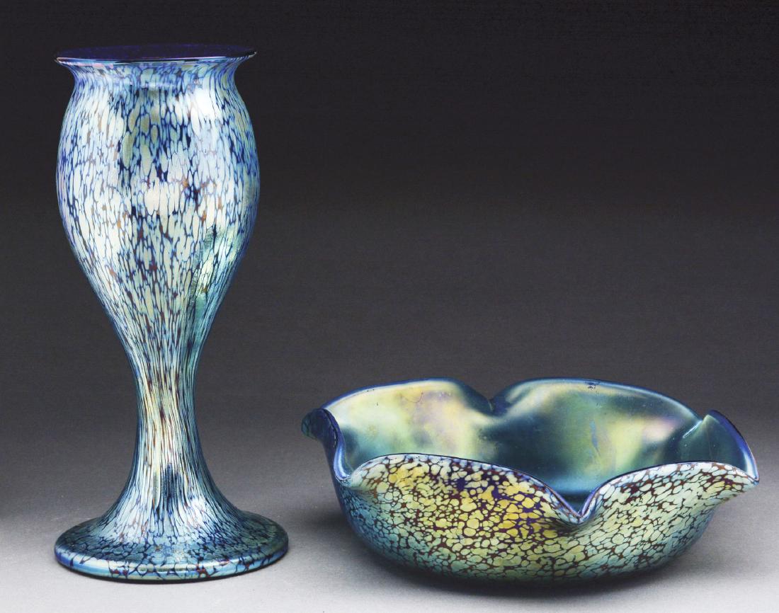 Two Loetz Papillon Vessels.: First is a Loetz vase in the Papillon genre has blue iridescent finish on a cobalt blue ground. Iridescent pattern shows platinum highlights. Unsigned. Very good to excellent; and second, a Loetz bowl