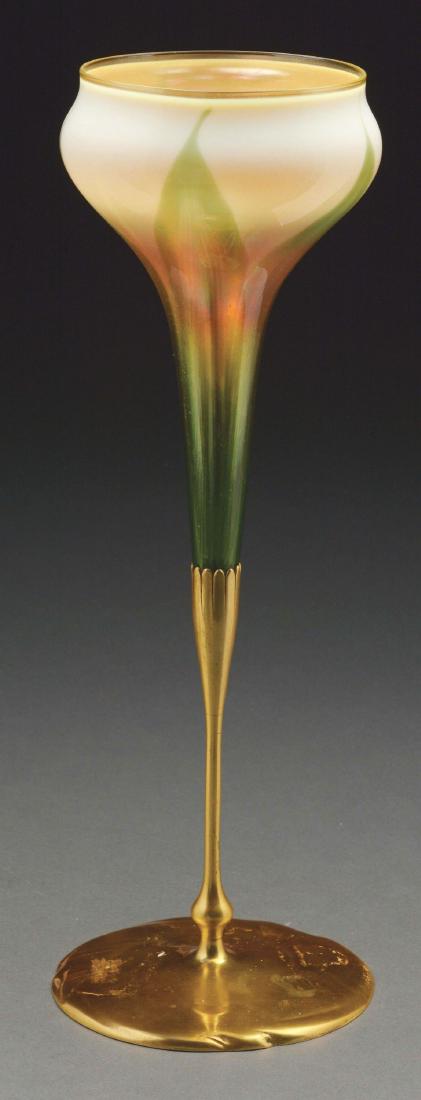 Tiffany Favrile Flower Form Vase.: Tiffany flower form vase has green pulled-feather design rising from the bottom against a slightly iridescent cream colored background. The vase is finished with a gold iridescent lip and is housed in