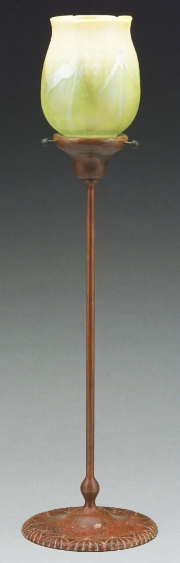 Tiffany Studios Candle Lamp.: Tiffany Studios candle lamp has cast bronze candlestick with an inverted saucer foot, decorated in an onion design around the foot, with a long slender stem leading to the candle cup and shade holder.