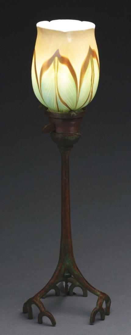 Tiffany Studios Root Candle Lamp.: Tiffany Studios cast bronze root candlestick has been factory electrified and is finished in rich brown patina with green highlights. The candlestick supports a Favrile glass shade with green pulled-f