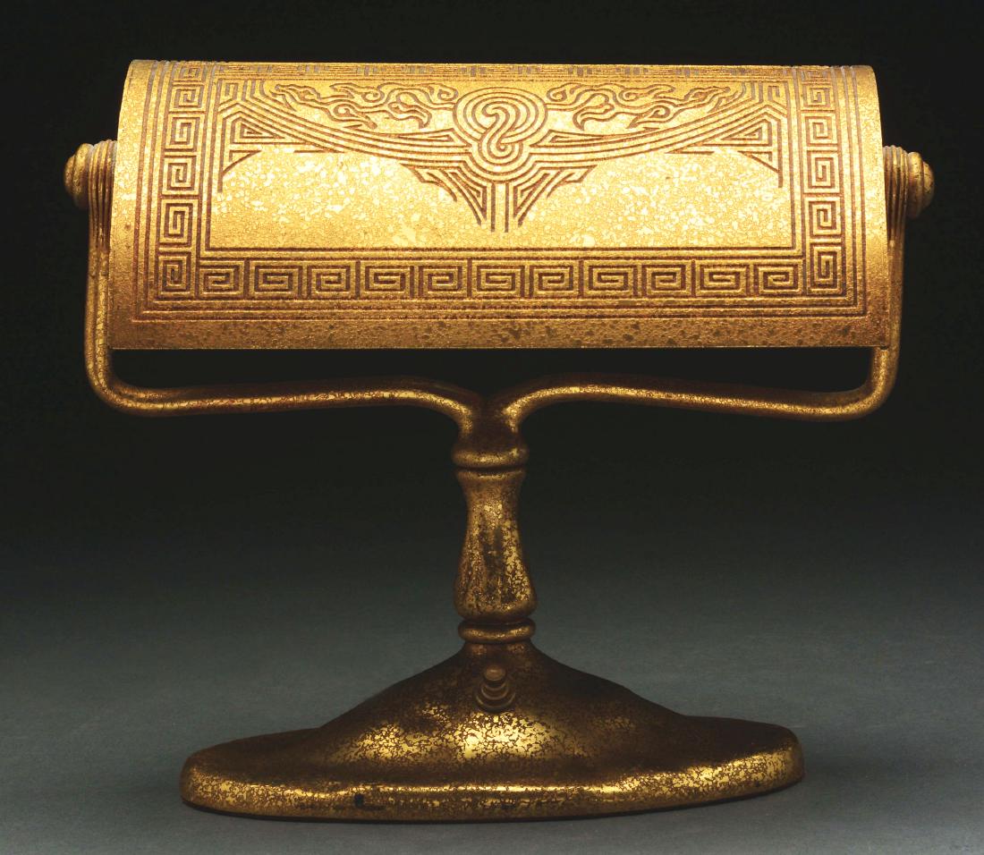 Tiffany Studios Chinese Desk Lamp.: Tiffany Studios bronze desk lamp in the Chinese pattern is outlined with a Greek key pattern with oriental stylized clouds and arches. The lamp is finished in gold dore and features the short stem. Th
