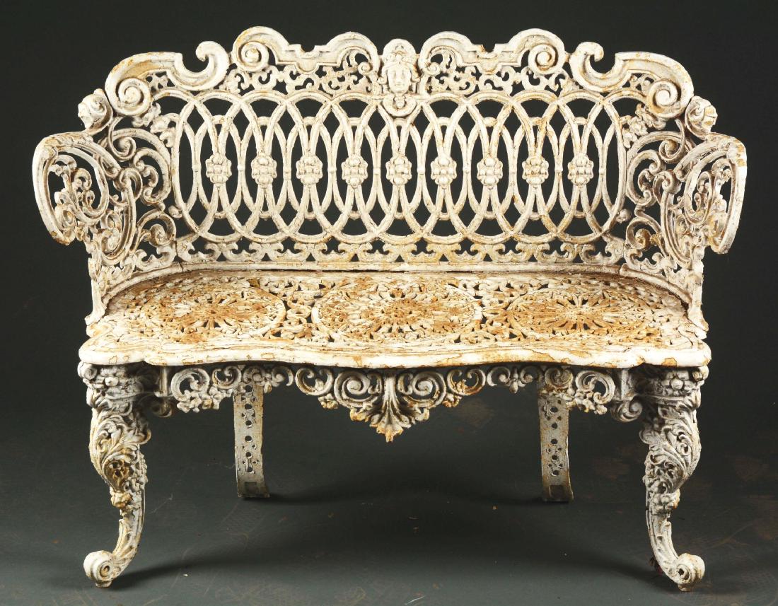 Fine Quality Cast-Iron Victorian Settee.: Last quarter 19th century. American. The settee with shaped crest centering a female bust, the back with pierced scroll elements in intricate design of overlapping ovals, each centered with rosettes. 