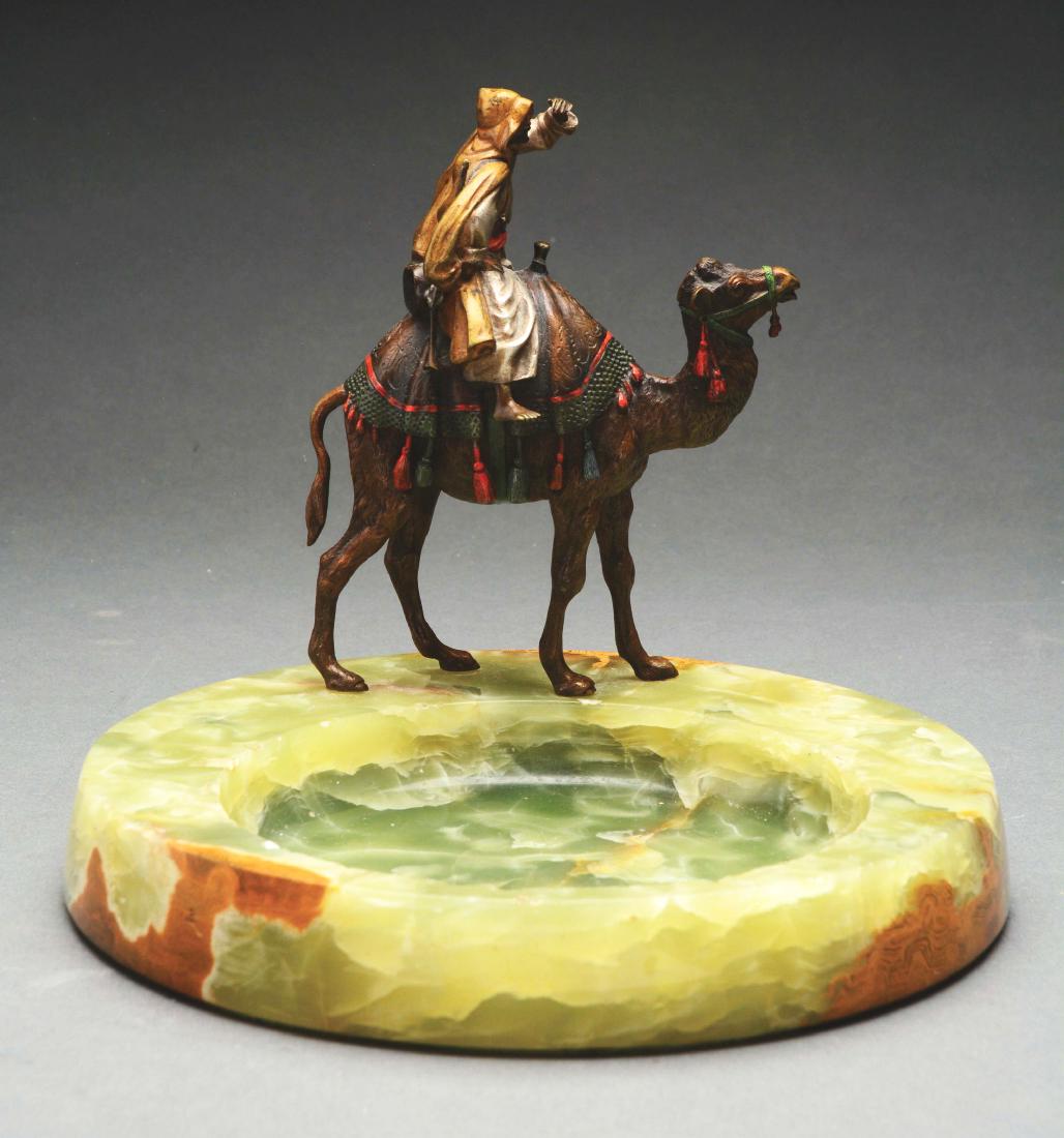 Vienna Bronze & Marble Decorative Ash Tray with Man on: The bronze figure of a man riding a camel stands on a green marble base. The ashtray has a 9-1/2" diameter and there are some chips to the tray.Paperwork: Condition: Dimensions: 8 -1/2" x 9 -1/2" x 9 