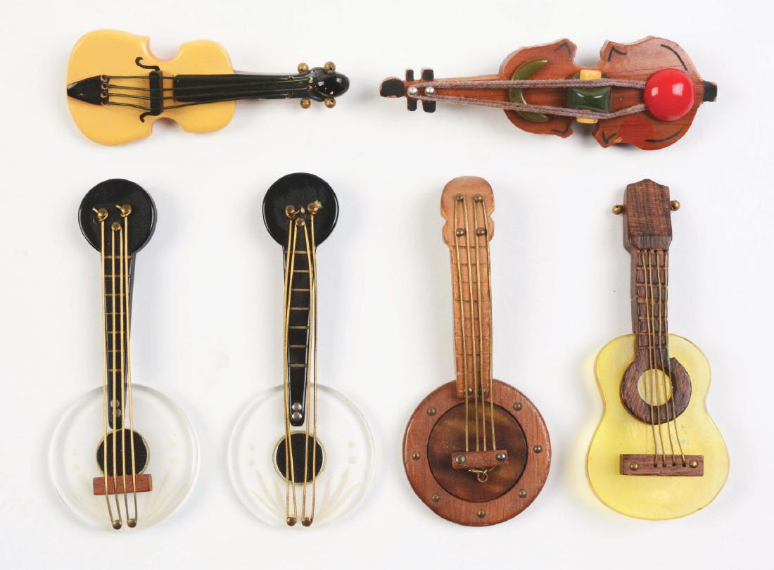 Lot of 6: Bakelite Guitar Pins.: Nice assorted grouping of bakelite guitars. Condition: (Excellent). Dimensions: Largest: 4" x 1 - 3/4".