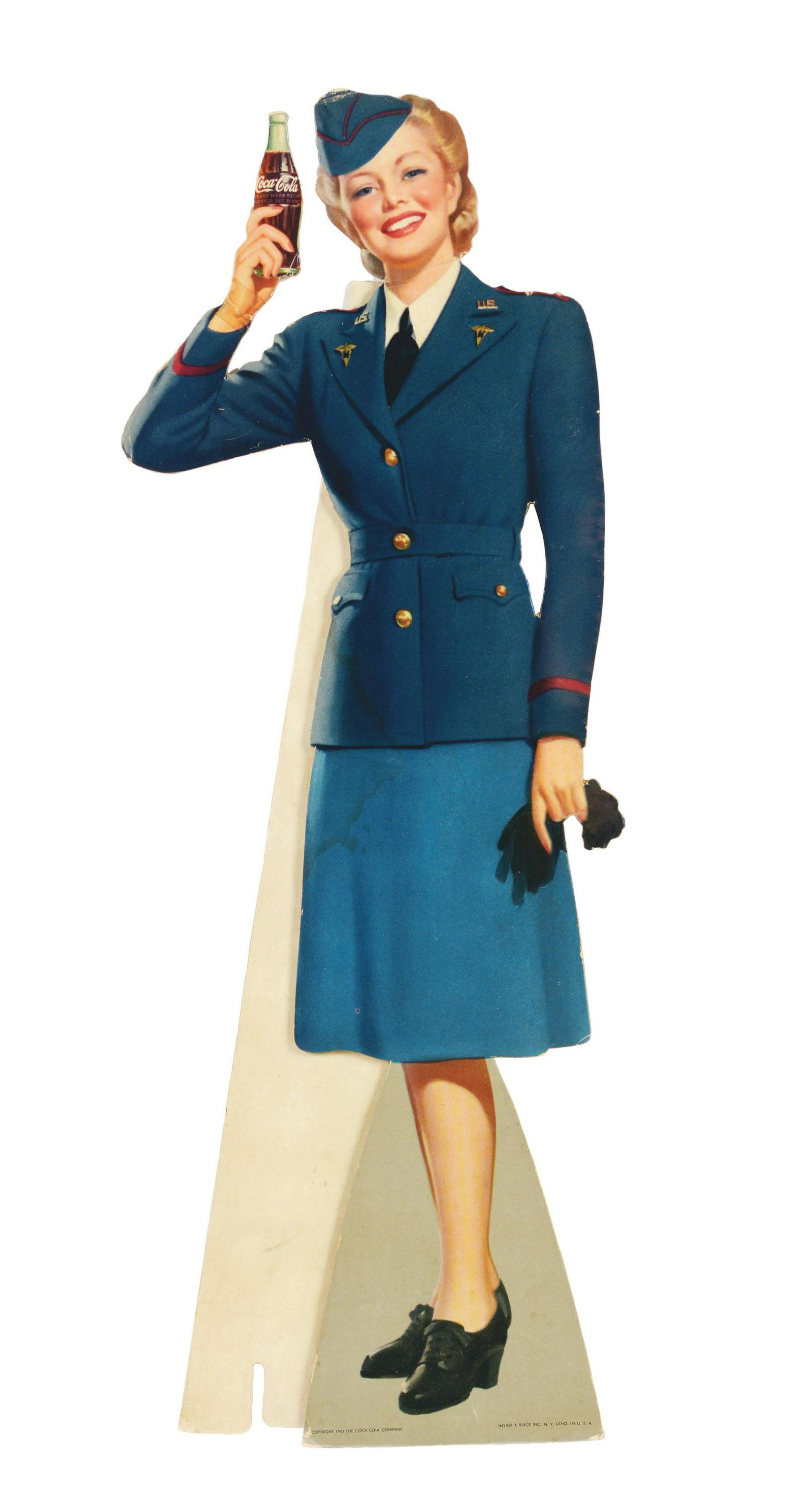 1943 Coca-Cola Cutout Servicewoman.: Like all of these, complete with the original easel. This example has a strong wrist bend with evidence of old tape repair. There is also a neck bend and a three-inch stain on the left side of her jac