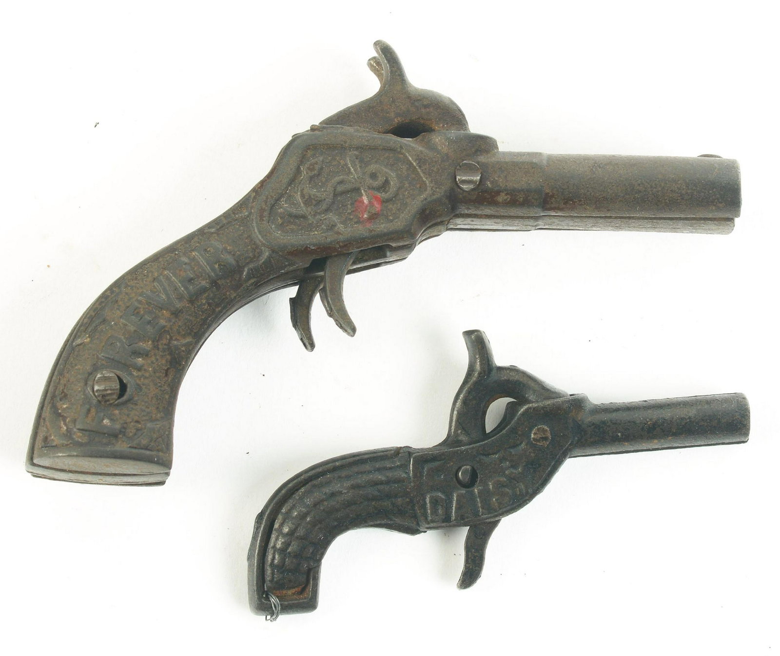 Lot of 2: Scarce late 19th Century Cast-Iron Cap: Both likely made by Stevens, circa 1880's. First one is a small Daisy one-shot, embossed "DAISY" on both sides; and second, a double-barrel Our Navy Forever, with nice engravings of a cannon and "OUR 