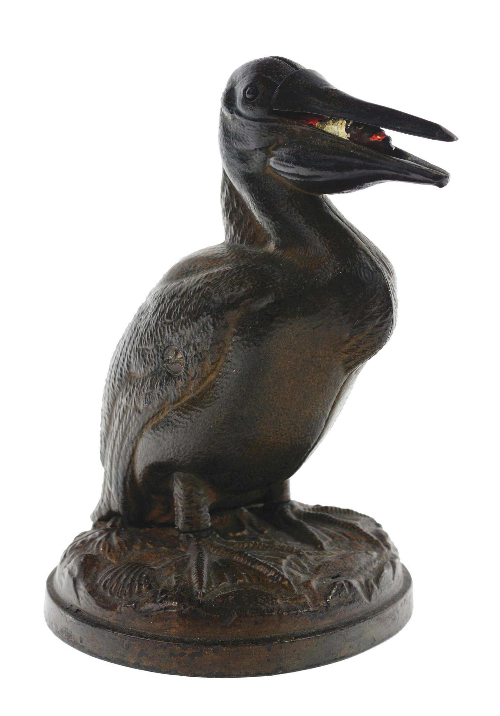 J. & E. Stevens Pelican Cast-Iron Mechanical Bank.: Place a coin in the slot on the pelican's head. This causes the mouth to open, exposing the figures head. Mammy variation. (JY) Condition: (Excellent). Dimensions: 8" x 5 - 1/4" x 4 - 3/4".