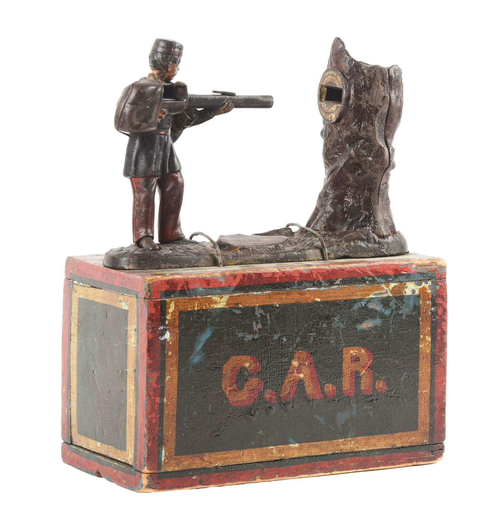 J. & E. Stevens Creedmore Cast-Iron Mechanical Bank.: Cock the rifle and place a coin on the barrel. Press the figure's right foot and the coin is shot at the target. As the coin enters the tree, it strikes a bell. Bank is mounted to a wooden painted box