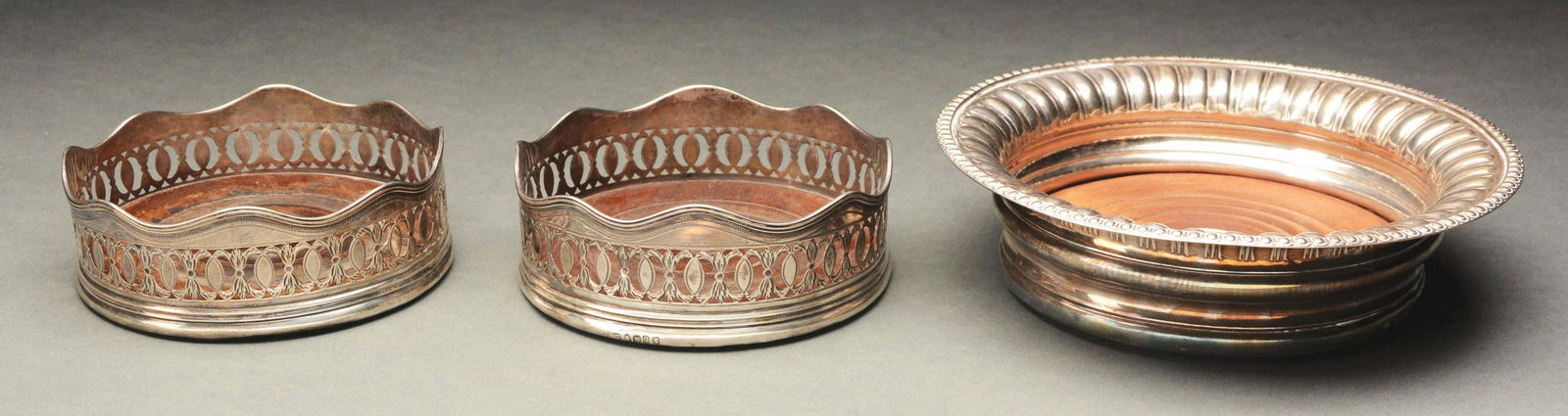 PAIR OF GEORGIAN SILVER WINE COASTERS TOGETHER WITH A: Later 18th to early 19th century. The magnum coaster, believed to the mark of John Roberts and Company, Sheffield, dated 1789. The coaster with everted gadrooned edge , hallmarks on the bottom rim at