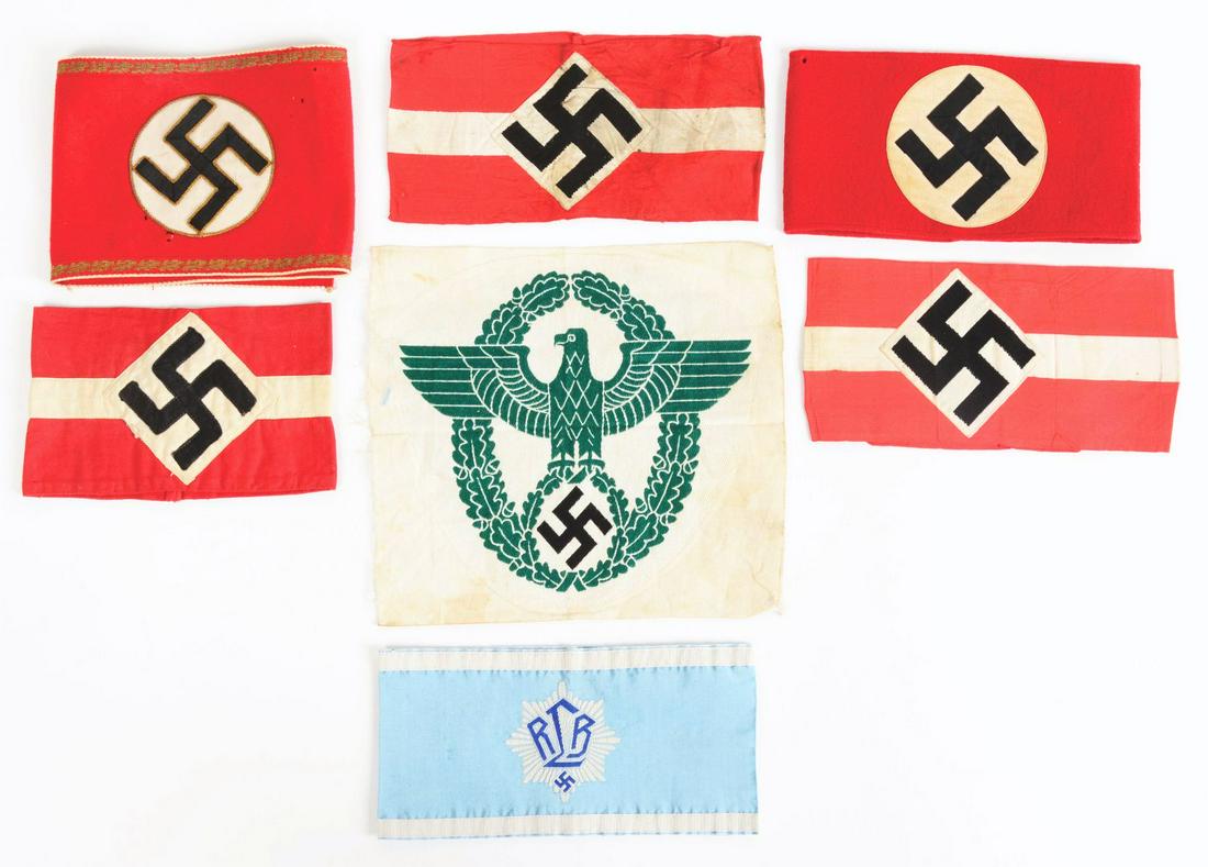LOT OF 7: GERMAN THIRD REICH ARMBANDS AND SPORT SHIRT: Lot consists of: (A) One RLB Officer's Armband. CONDITION: Excellent. (B) One wool NSDAP Armband with minor soiling to the white swastika disc and two light moth nips. CONDITION: Very good. (C) One tw
