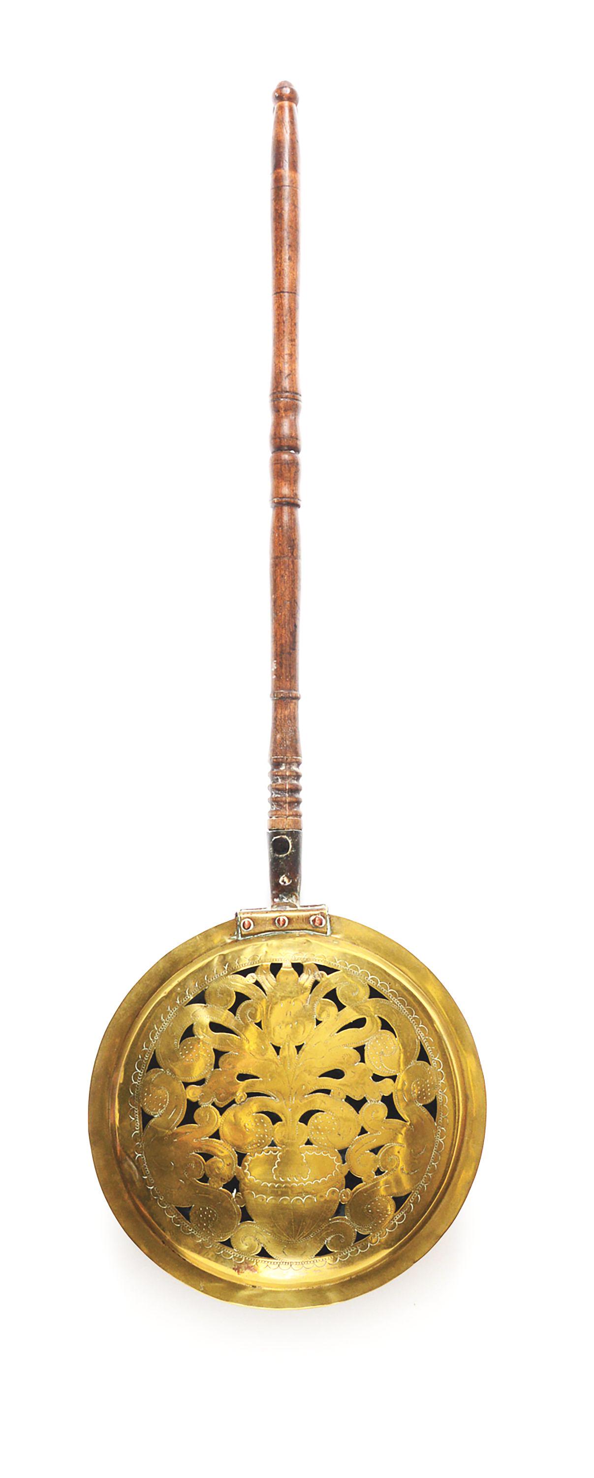 BED WARMER. ENGLISH OR AMERICAN. BRASS, COPPER AND ASH.: A turned wooden handle in a copper sleeve riveted to the brass warming pan with a pierced and engraved top. The engraved, pierced design consisting of foliated ornament and a large, centered vase. Thi