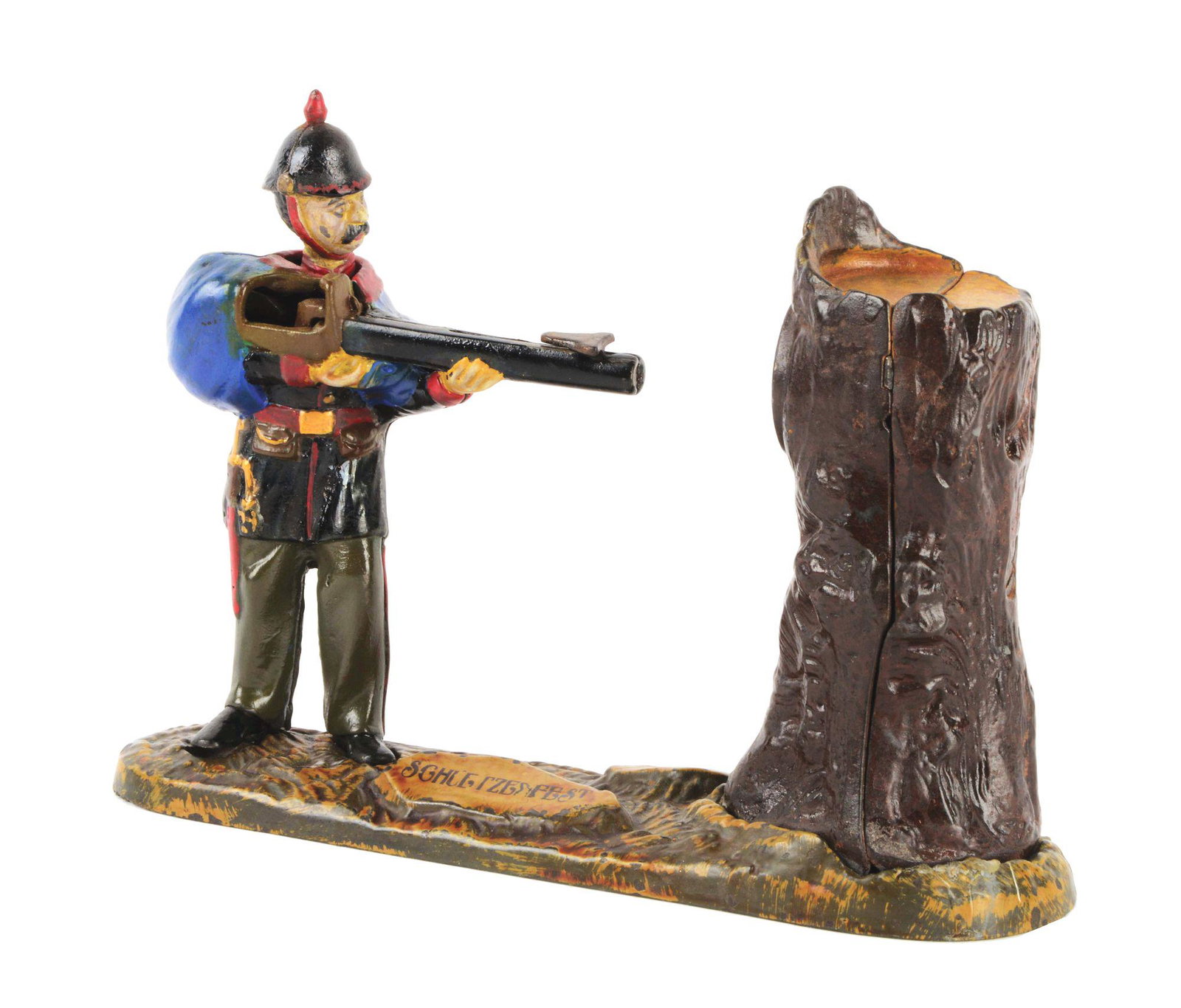 GERMAN HELMETED SOLDIER CAST IRON MECHANICAL BANK.: Cock the rifle and place a coin on the rifle. Press lever and the coin is shot into the tree. This is a scarce bank. CONDITION: Areas of touch up, overall excellent. (JY) Dimensions: 10" X 2 - 3/4" X 