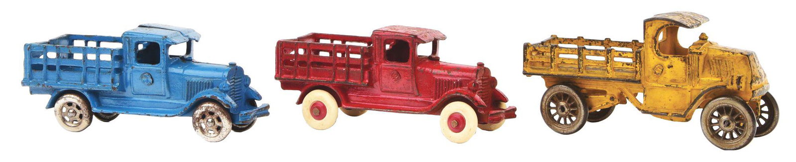 LOT OF 3: CAST-IRON A. C. WILLIAMS STAKE BACK TRUCKS.: Similar trucks. The red and blue one are fairly identical except for wheels, which are steel spoke wheels on the blue truck. The yellow truck is more of a Mack front with a shorter back base and is wi