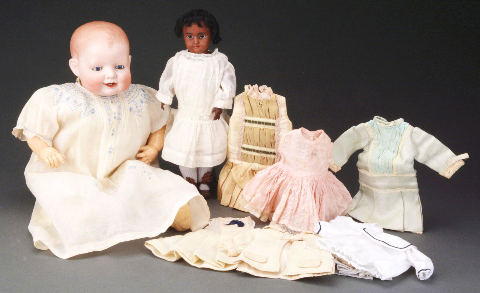 LOT OF 2 GERMAN BISQUE DOLLS EARLY 20TH CENTURY.: The larger of the two, 22" long, 15" head circumference, is a flange neck baby with molded and painted hair, glass sleep eyes, an open mouth with two lower teeth and a separate tongue, smiling with de