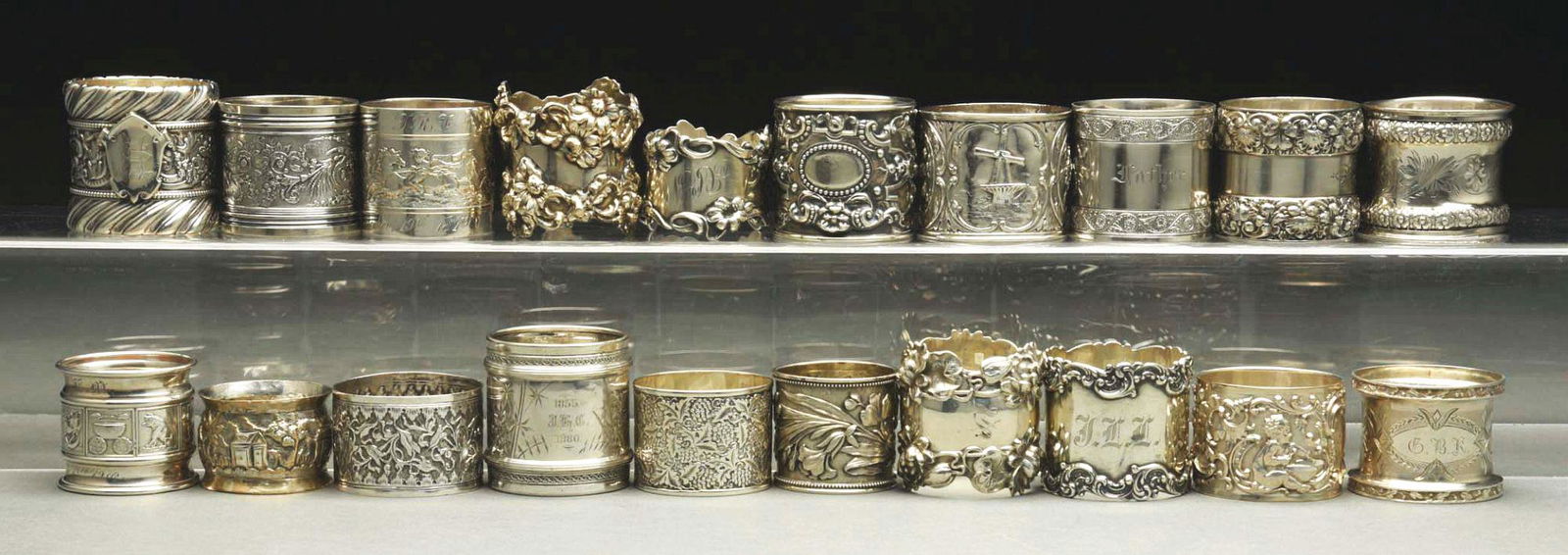 LOT OF 20: STERLING SILVER NAPKIN RINGS.: c. 1860 - 1910. Lot includes seven Gorham, an unmarked Tiffany, one scenic ring with houses, a Russian, an 1890 Dutch with sailboats, another Tiffany, an Austrian with Cherubs, a 1900 Indian Colonial,
