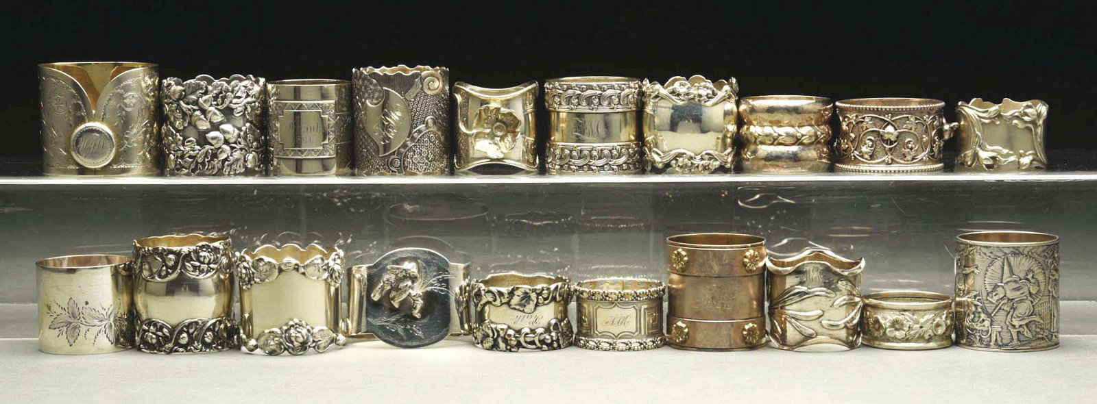 LOT OF 20: STERLING SILVER NAPKIN RINGS.: c. 1850 - 1910. Lot includes a coin "collar", two 1860 coins, an 1860 H. G. Wood, an unmarked Tiffany with birds, two Jenkins, an 1884 W. H. France, an Art Nouveau, an Unger, a floral Shreve with acor