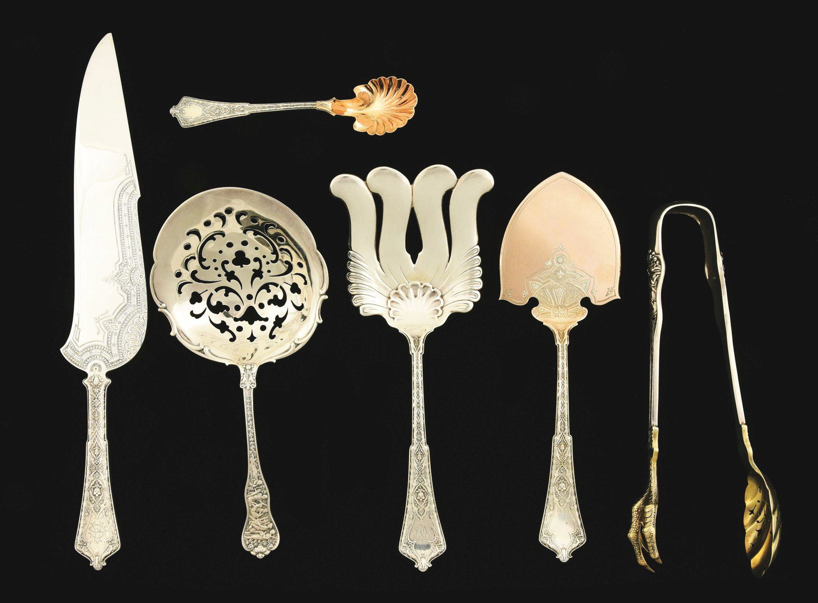 A GROUP OF TIFFANY STERLING SERVING PIECES.: Persian pattern, including an ice cream knife with a shaped blade, another server with a short pointed flat blade; a sugar spoon with a gilt shell-shaped bowl; and an asparagus fork; together with an 
