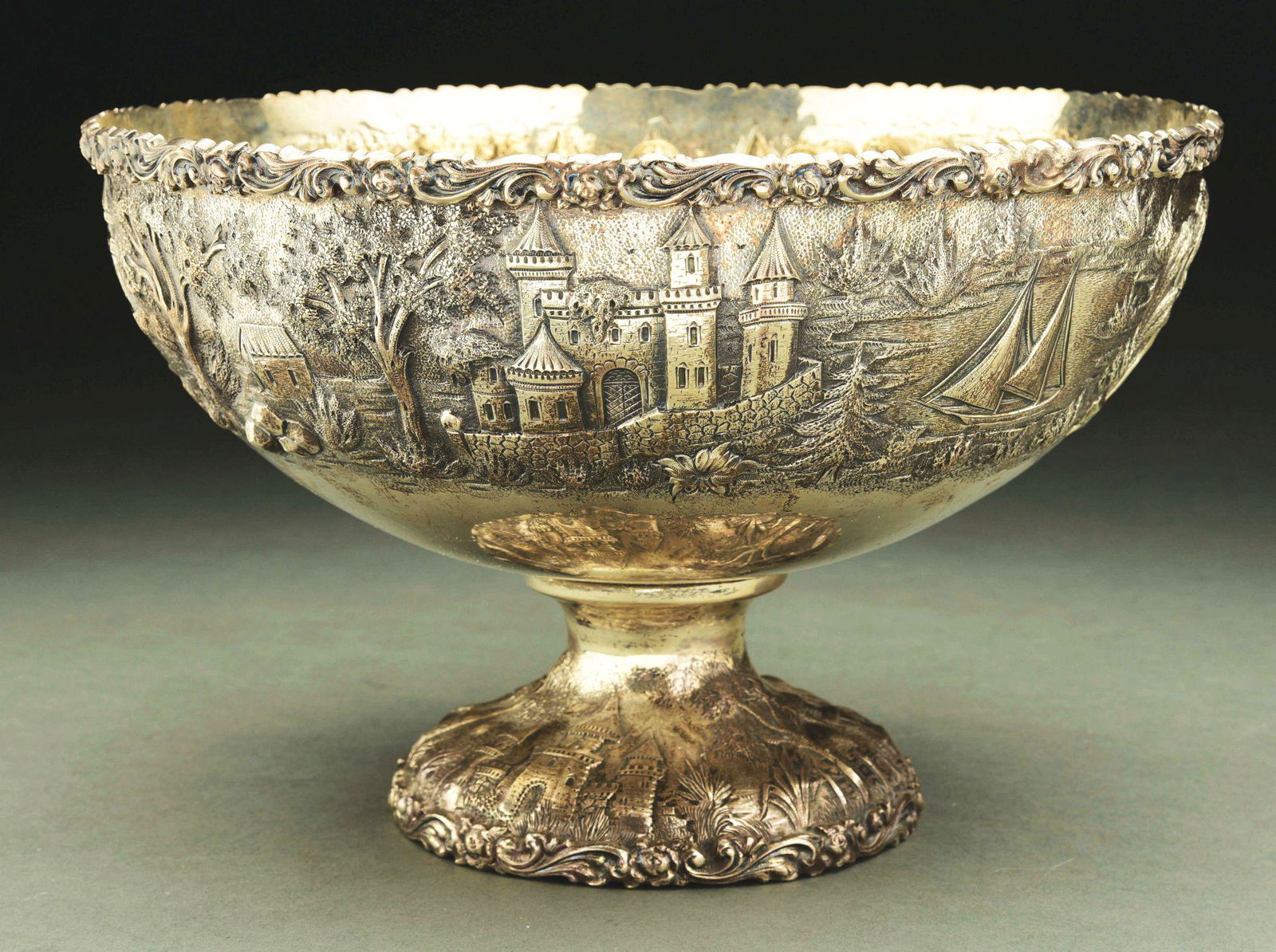 AN AMERICAN STERLING CENTER BOWL.: Baltimore Silversmiths Mfg. Co. Circular, the sides chased with a continuous scene with castles, palaces and boats in a landscape. Diameter: 10 - 1/4" Weight: 28.1 ozt. Condition: Dimensions: 6 - 5/8"