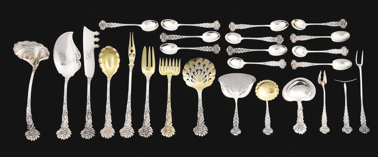 A GROUP OF TIFFANY STERLING FLATWARE.: Including Holly pattern: a butter knife, nut scoop, pierced nut scoop, sugar spoon, small gravy ladle, gilt hors d’oeuvres fork, jelly server, and another fork; and Holly and Mistletoe pattern: a nu