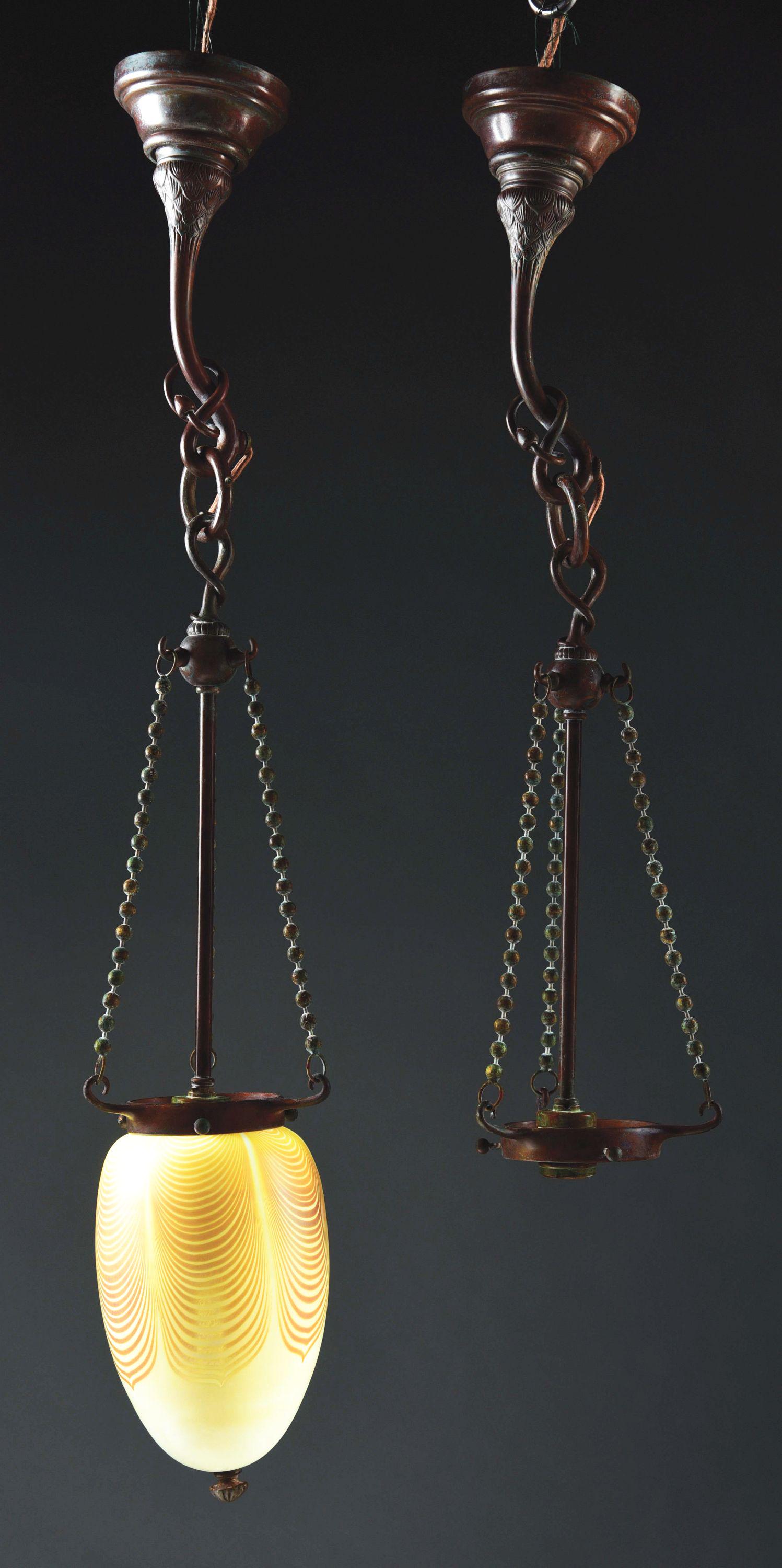 PAIR OF TIFFANY SCONCES/CHANDELIERS.: Tiffany Studios patinated cast bronze and glass chandeliers/sconces decorated with an over sized early pulled feather shade suspended from three ball chains accompanied with very organic hardware whic
