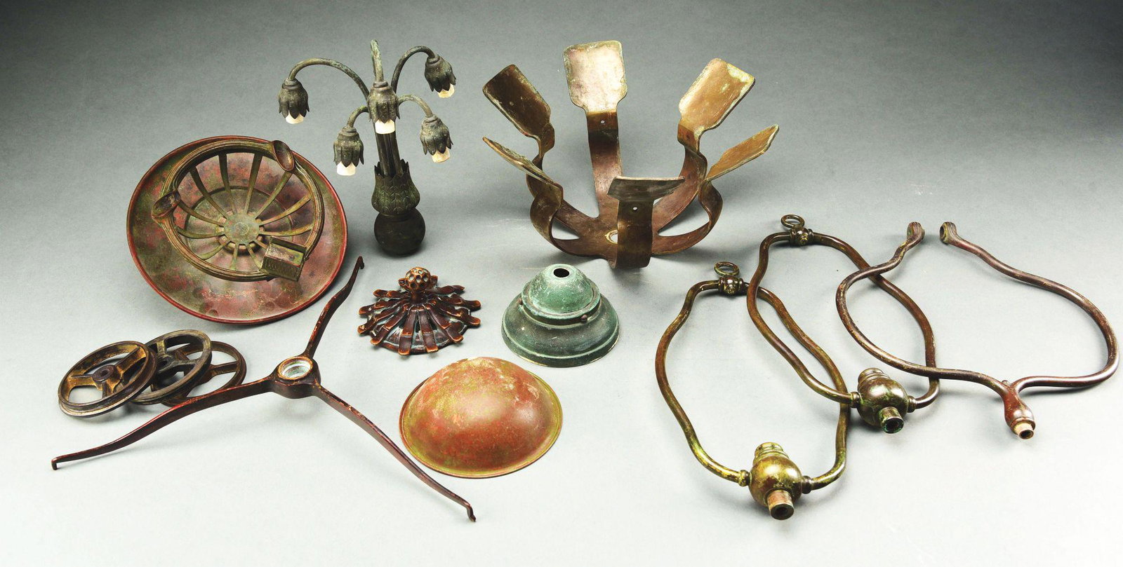 TIFFANY STUDIOS LAMP PARTS.: A box lot of assembled lamp parts and pieces by Tiffany Studios. Ashtray part, Lily sconce and backplate, large canopy, three wheels, one set of spider arms, two shade holders, band and bamboo reprodu