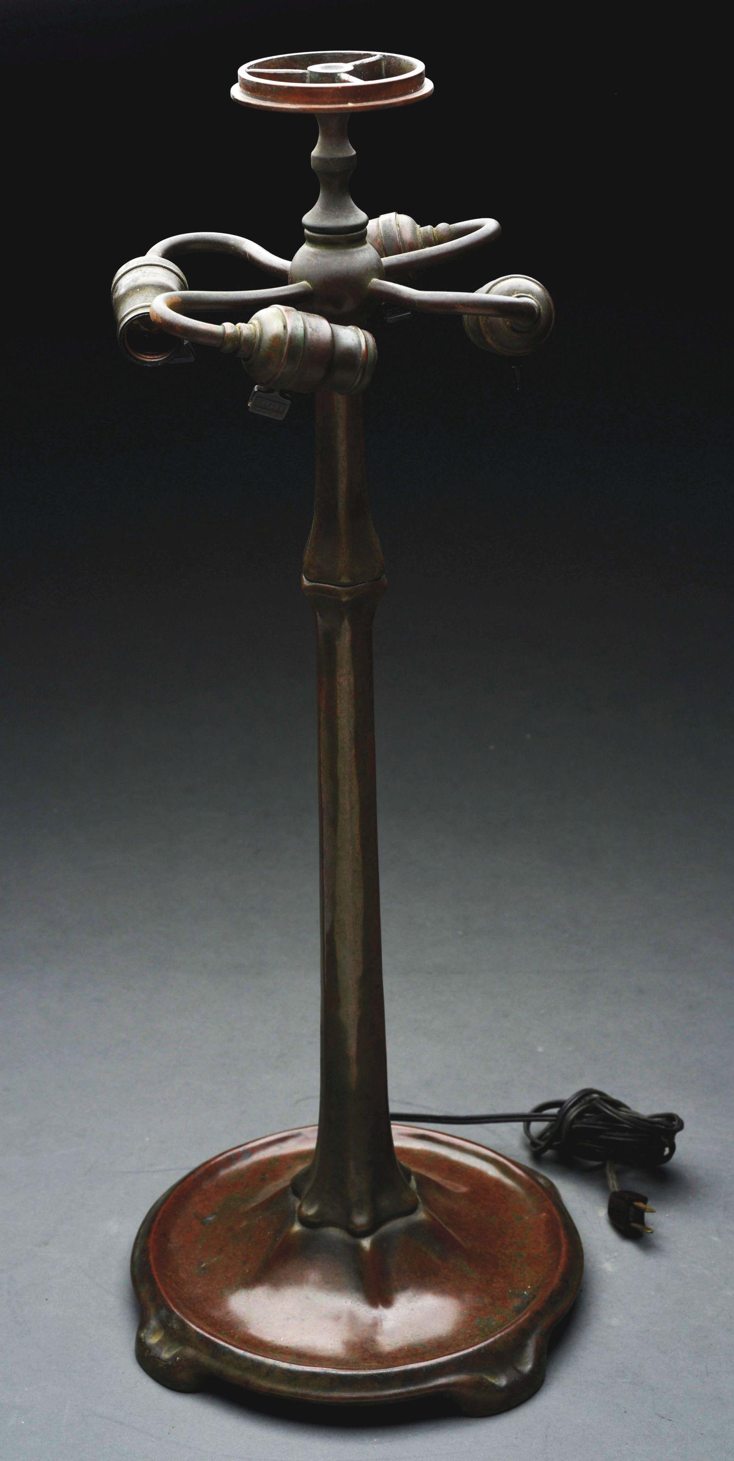 TIFFANY STUDIOS BRONZE STICK BASE.: Tiffany Studios lamp base has cast bronze foot with simple hexagonal shaft leading to the three-socket cluster. The base is finished in a brown patina with green highlights and topped with a heat cap.