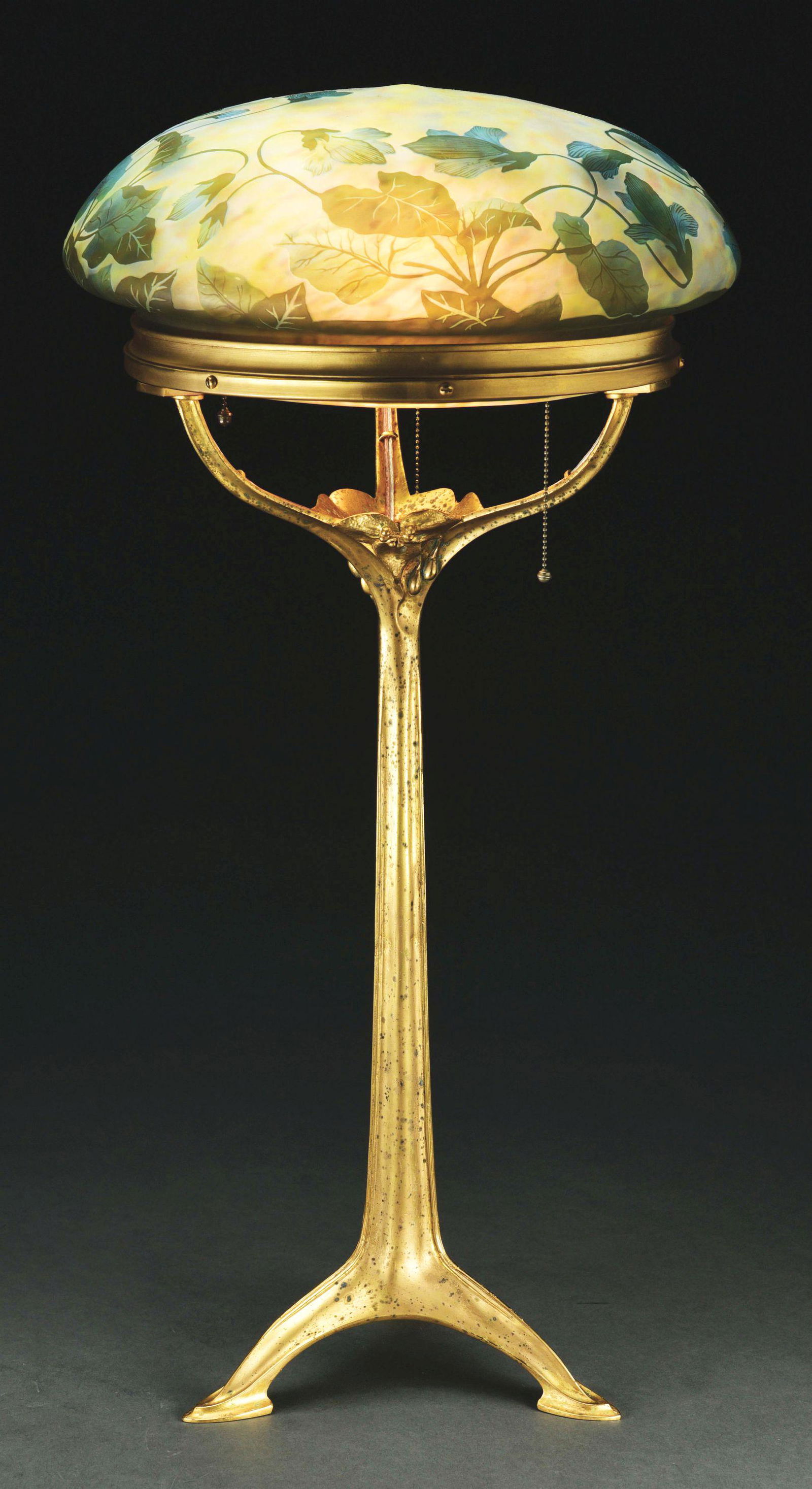 MAJORELLE AND DAUM NANCY ART NOUVEAU TABLE LAMP.: A French Art Nouveau gilt bronze lamp base by, Majorelle decorated with a signed Daum Nancy etched and carved domed shaped shade. The shade is signed "Daum Nancy". Condition: (Excellent). Dimensions: