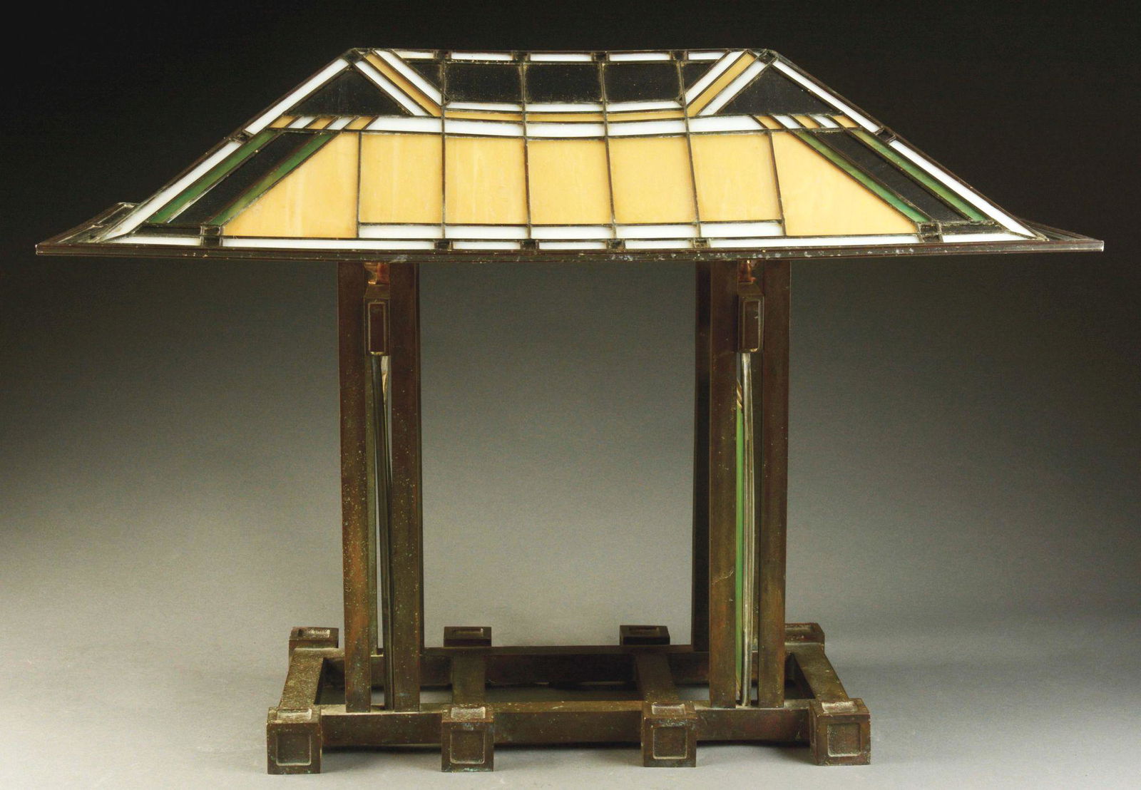 CONTEMPORARY PRAIRIE STYLE TABLE LAMP.: Contemporary prairie style table lamp by Porcelli Studios has rectangular shade with Frank Lloyd Wright inspired geometric design in amber, green, and white glass. The shade rests on a heavy bronze ba