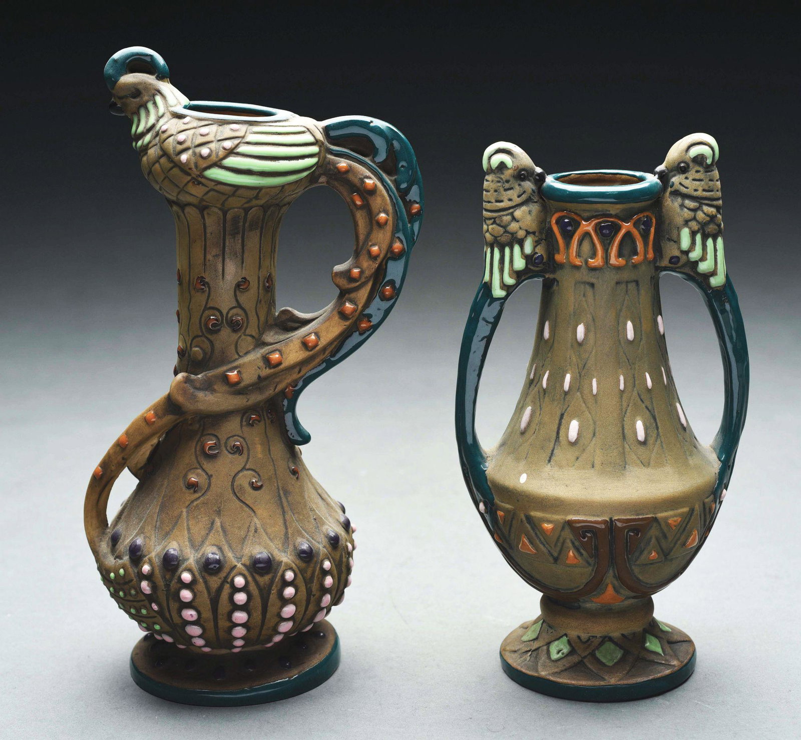 PAIR OF AMPHORA HANDLED BIRD VASES.: The first is with two applied bird handles, the other with a bird sitting at top with extrude tail handle. Amphora Crown mark, Amphora Oval mark, Austria Oval mark, impressed "15015-G". 8 - 1/4" high.