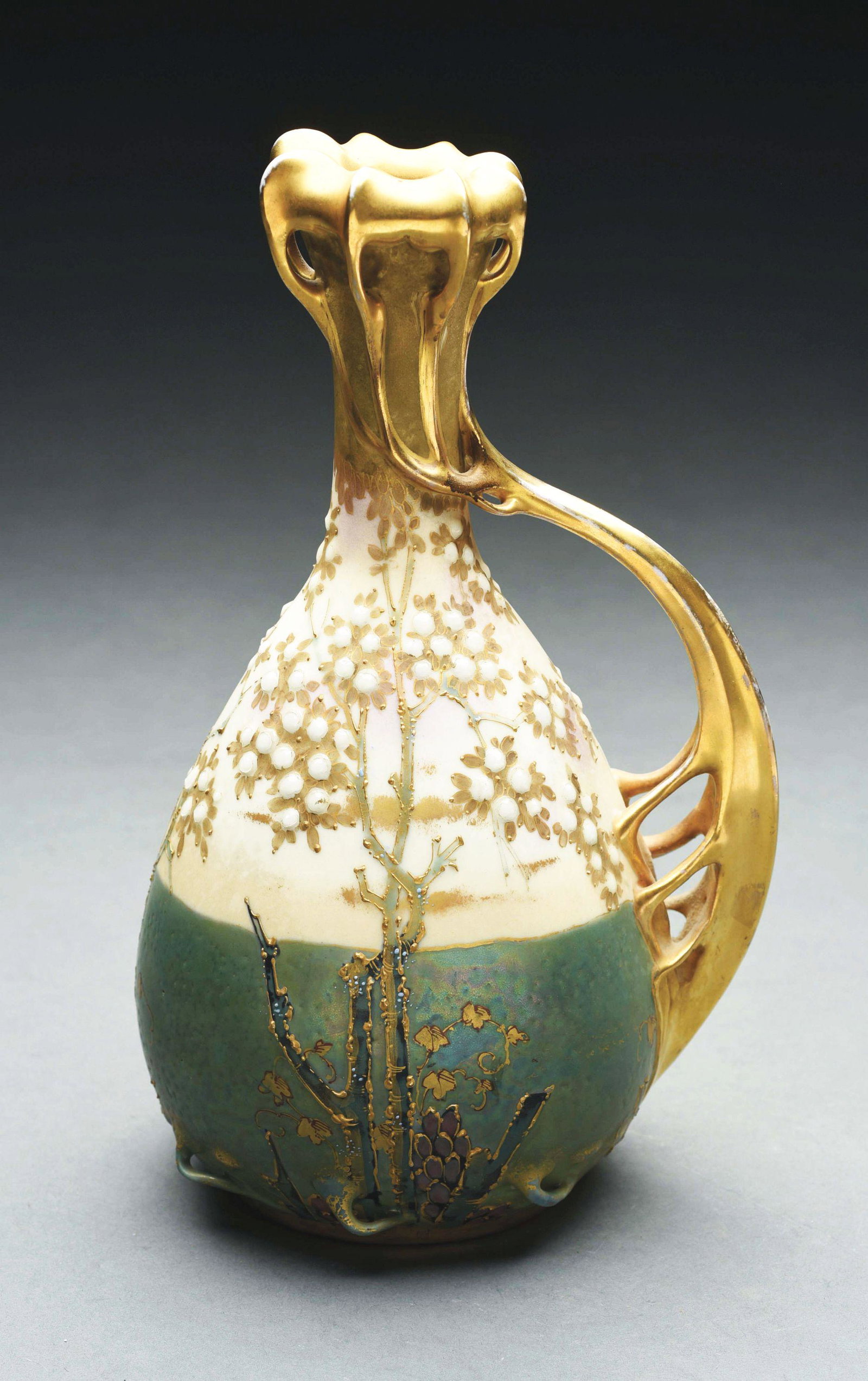 AMPHORA VASE WITH INTRICATE FLORAL DESIGN.: A rare Paul Dachsel designed vase. Gold gilt stylized handle, applied plum trees with enameled flowers. Ivory based body, iridized green bottom with extruded handles around the base. Crown mark, Austr