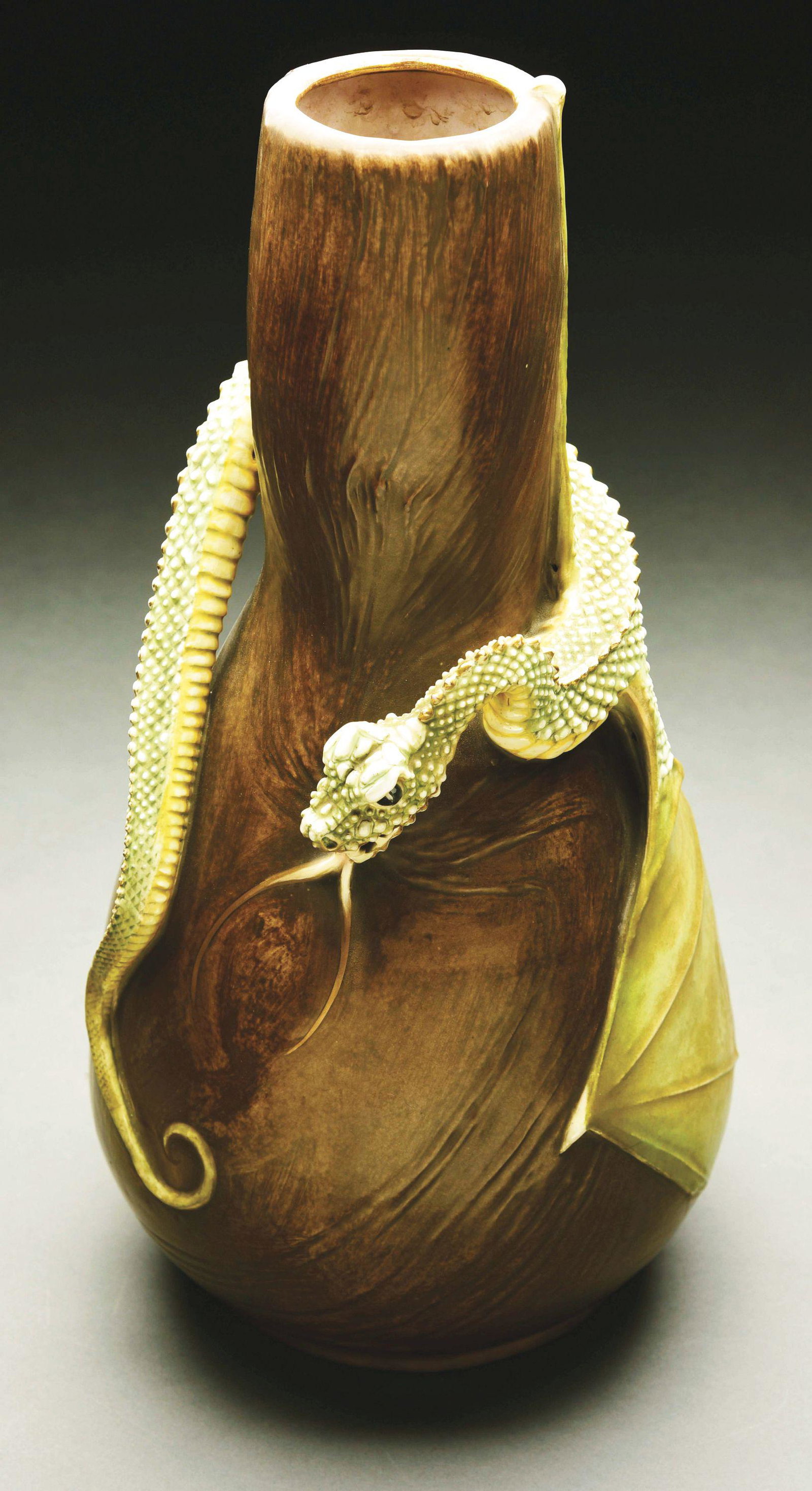 EDUARD STELLMACHER MONUMENTAL WRAPPED WING DRAGON VASE.: Rare applied high-fired green and pearlized white glazed dragon on reddish brown body. Stellmacher Teplitz mark. Impressed "9". Painted “333-92/W". Model illustrated in "Monsters and Maidens: Collec