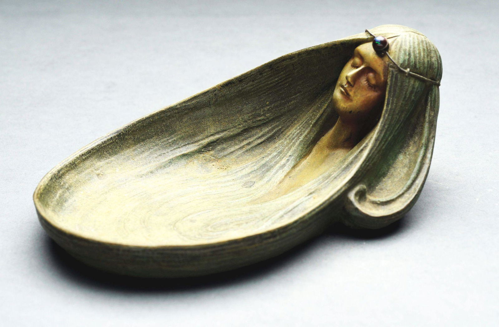 GUSTAV GURSCHNER "OPHELIA" FIGURAL ART NOUVEAU BOWL.: c. 1910. Head of a sleeping woman with hair shaped into a bowl with glass button on forehead. Bronze-colored cast iron, signed on the edge "Gurschner depose Vienne". Condition: (Excellent). Dimensions