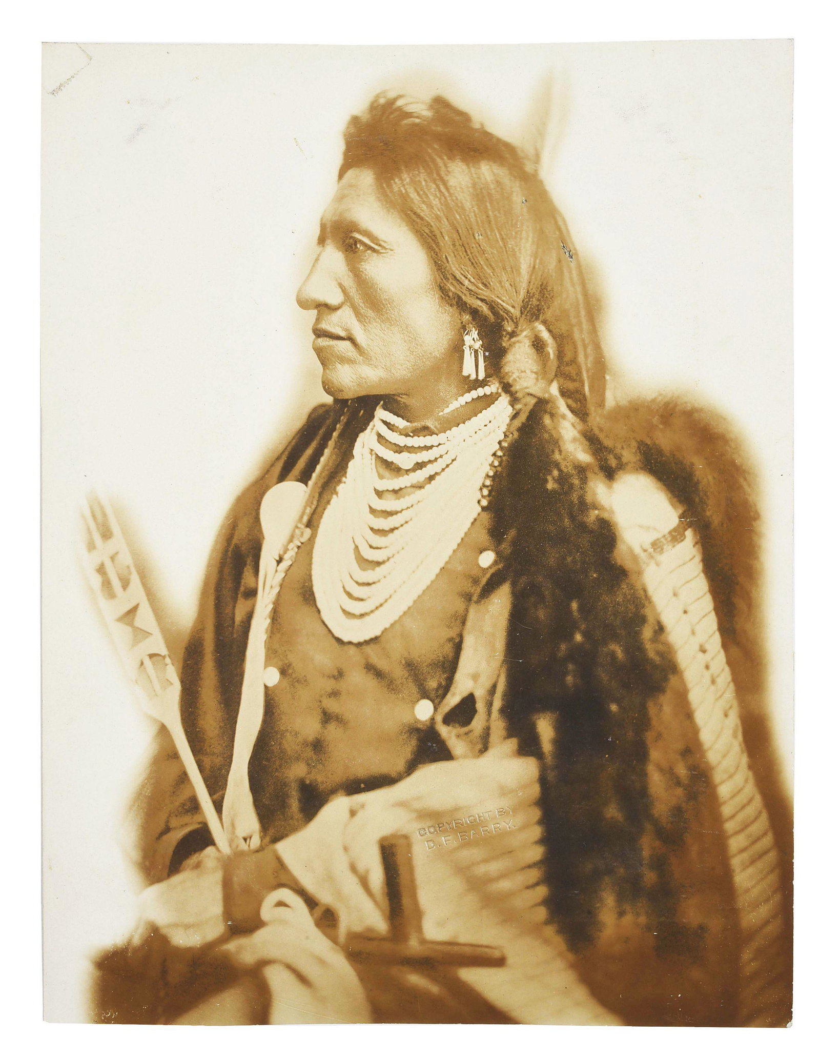 CHIEF GOOSE BY D.F. BARRY IN FRAME.: Sepia toned photo of Chief Goose by D.F. Barry. Photo measures 6-7/8" X 9-1/8". Noted on the reverse is "Chief Goose. Sioux Scout taken when they were on the Warpath in 1879". The reverse retains part